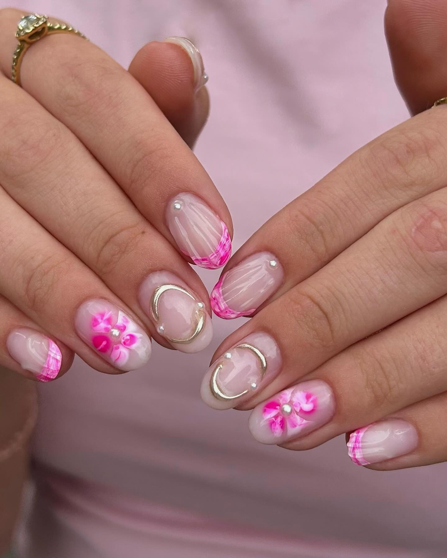 Roze French nail art met bloemen, parels en zilveren lijnen